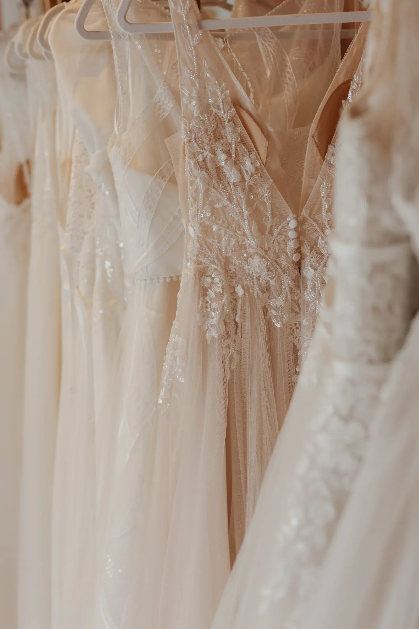 Ausgewählte Brautkleider mit Spitze hängen im Wertvoll-Atelier.