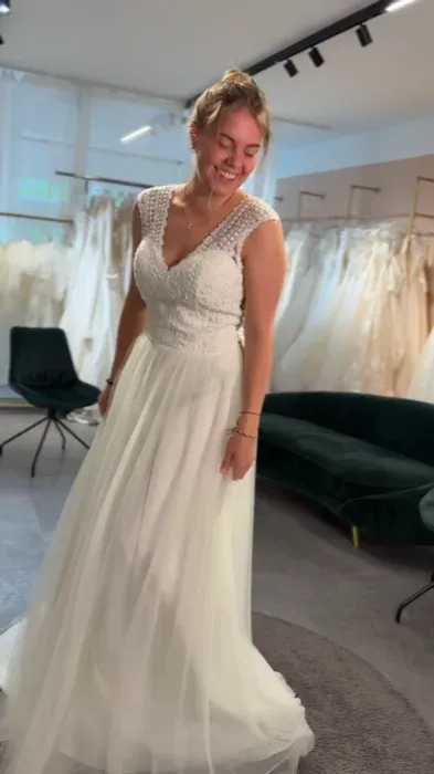Lächelnde Braut in einem hellen Brautatelier.